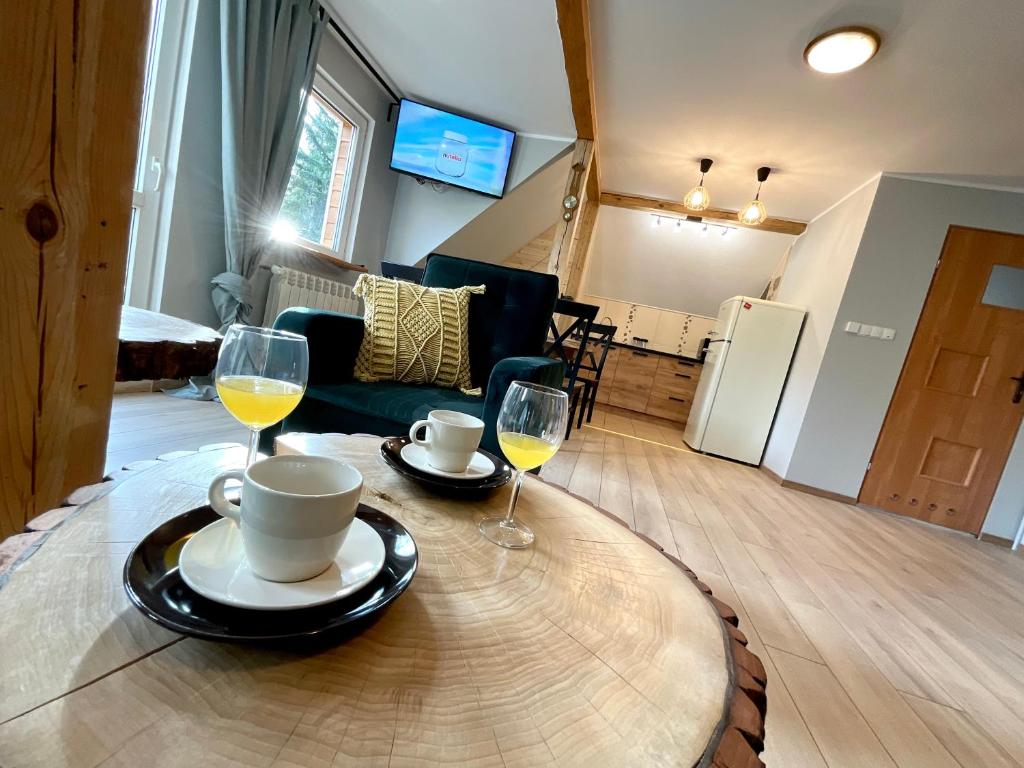 a table with two glasses of wine on top of it at Apartament Karkonoska in Przesieka