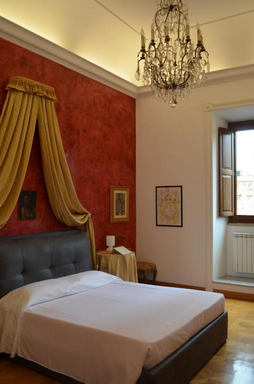 een slaapkamer met een bed en een kroonluchter bij Elegante appartamento nel centro di Roma in Rome