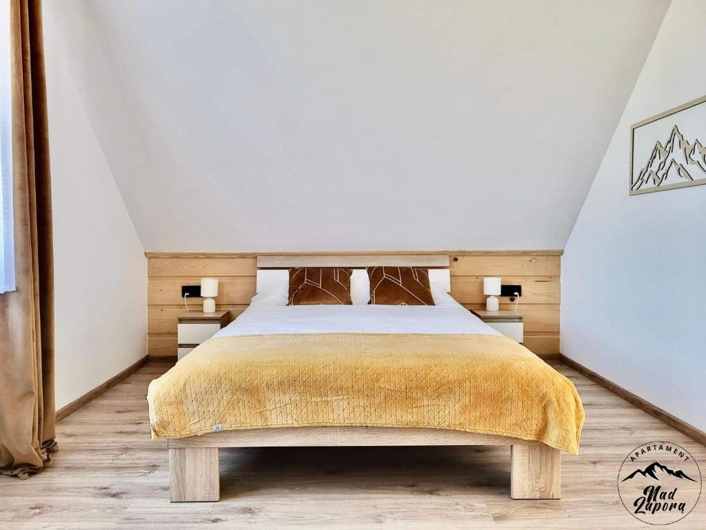 - une chambre mansardée avec un grand lit dans l'établissement Apartament Nad Zaporą, à Szlembark