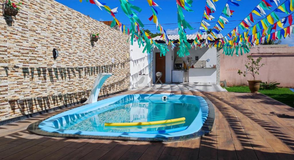 a blue swimming pool on a wooden deck with flags at Casa Laguna - Barra Jacuípe in Camaçari