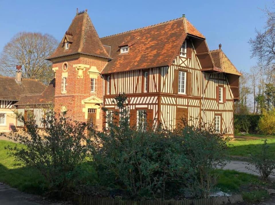 ein altes Haus mit einem großen Backsteingebäude in der Unterkunft Manoir Normand au cœur d’un Domaine Equestre in Saint-Samson