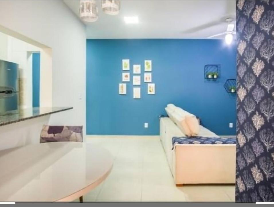 uma sala de estar com um sofá e uma parede azul em Apartamento Top em Itaguá em Ubatuba