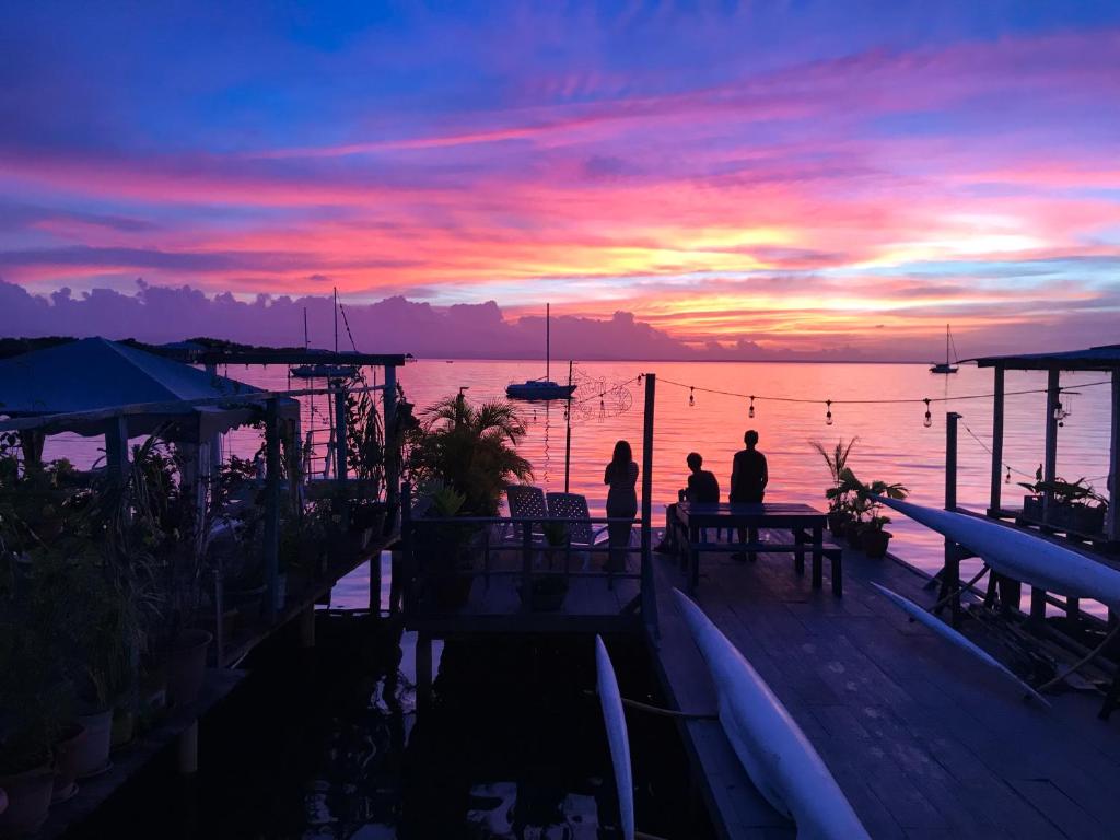 Eine Gruppe von Menschen, die auf einem Dock stehen und den Sonnenuntergang beobachten. in der Unterkunft Saigon Bay Bed & Breakfast in Bocas del Toro