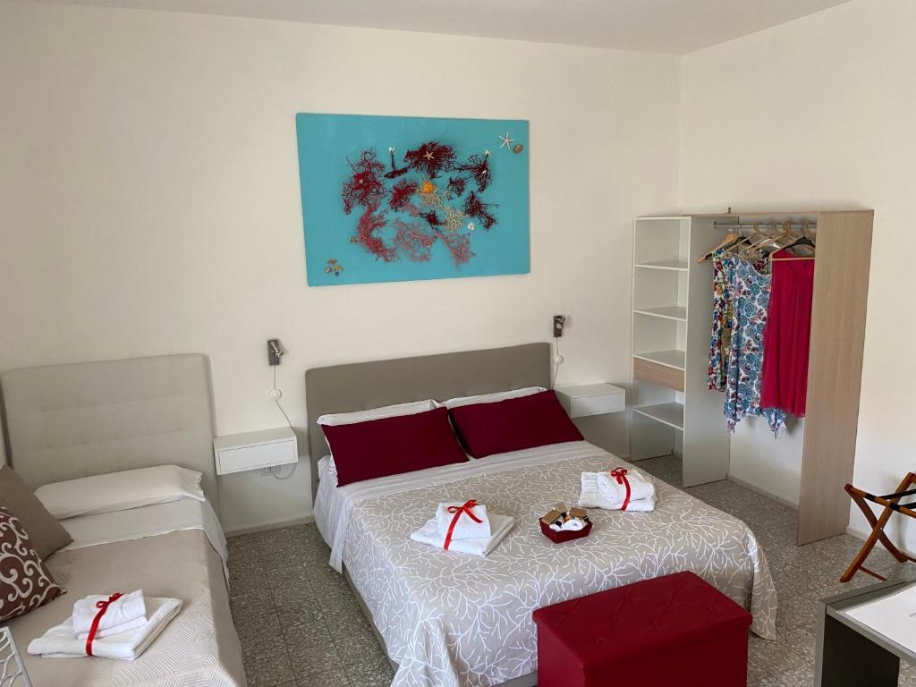 um quarto com uma cama com almofadas vermelhas em Rossocorallo Rooms em Alghero