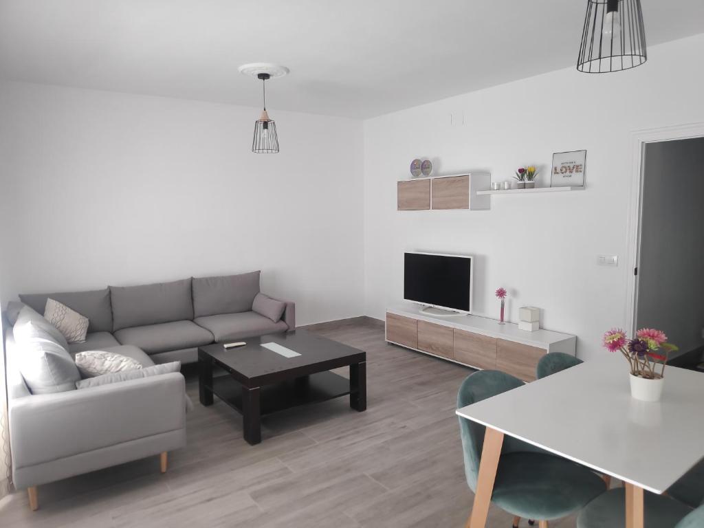 a living room with a couch and a table at Apartamento espacioso, nuevo, luminoso y acogedor in Casar de Cáceres