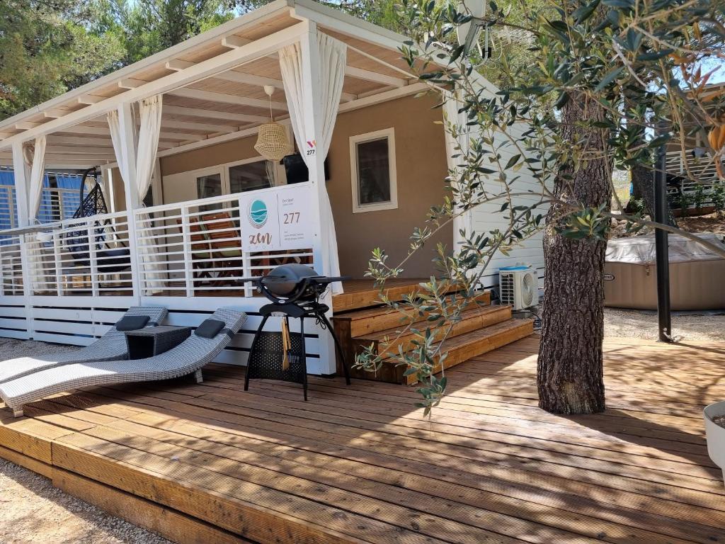 una casa con una terraza de madera con un árbol en Premium Mobile Home ZEN SPOT 277, en Jezera