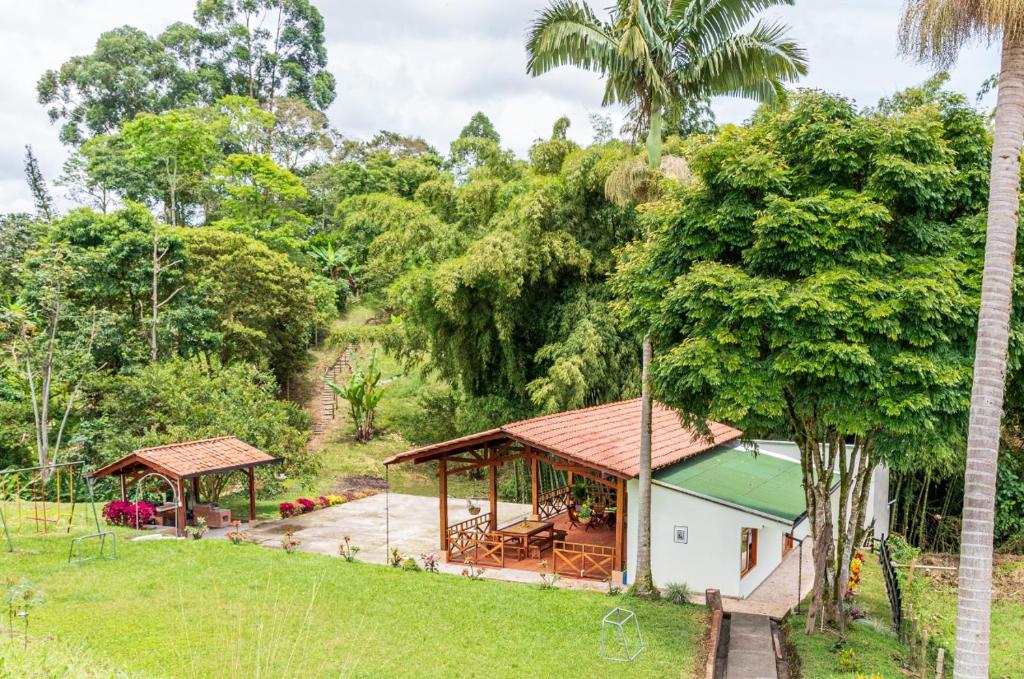ein Haus inmitten eines Feldes mit Bäumen in der Unterkunft Agradable cabaña cafetera con jacuzzi a 12 min del centro de pereira in Pereira