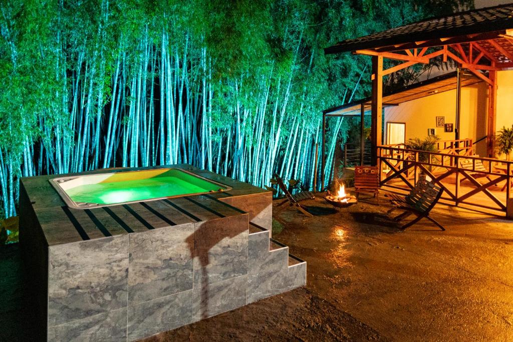 a room with a swimming pool in front of a bamboo wall at Jacuzzi Privado Eje Cafetero, bambú Naturaleza&paz a 12 min de la ciudad in Pereira
