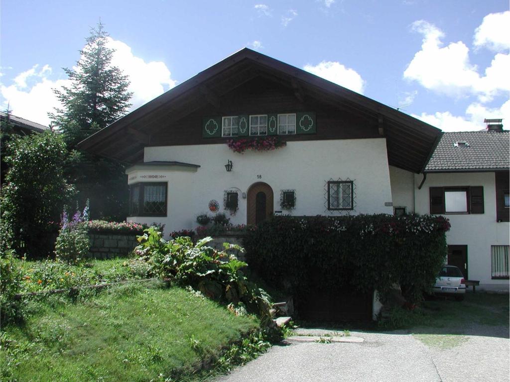 ein großes weißes Haus mit schwarzem Dach in der Unterkunft Ferienwohnungen Schnarf in Olang