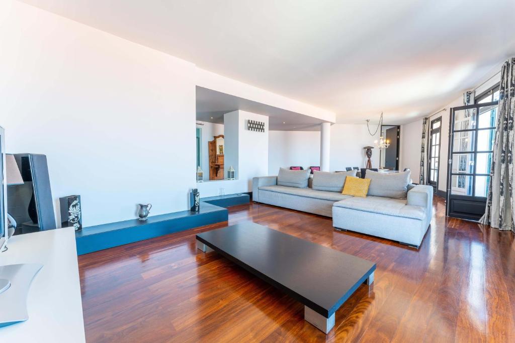 uma sala de estar com um sofá e uma mesa em FLH Funchal Artistic Apartment with Balcony em Funchal