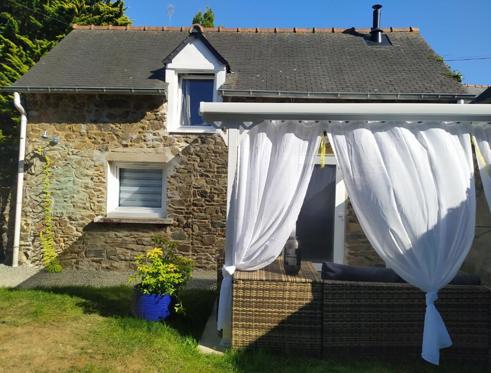 a cottage with a white curtain in front of it at Maisonnette de bord de mer in Étables-sur-Mer