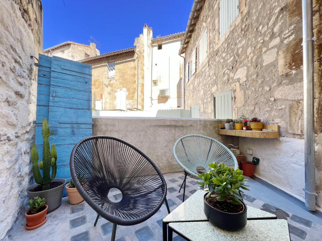 duas cadeiras e uma mesa num pátio com plantas em Spacious 2br in Arles Historical Center With Terrace em Arles