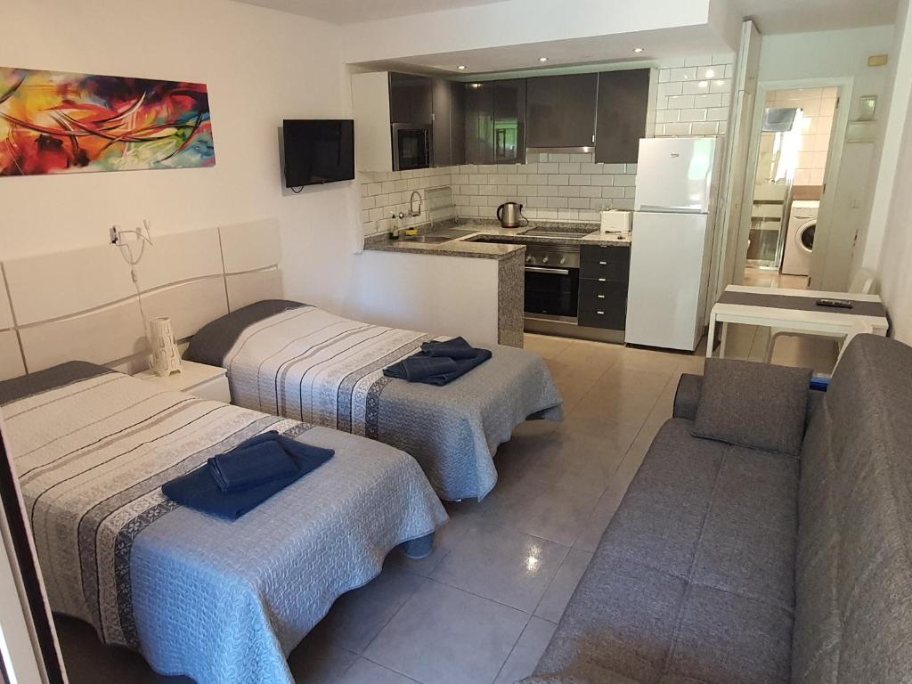 ein Hotelzimmer mit 2 Betten und einer Küche in der Unterkunft Minerva Suite in Benalmádena