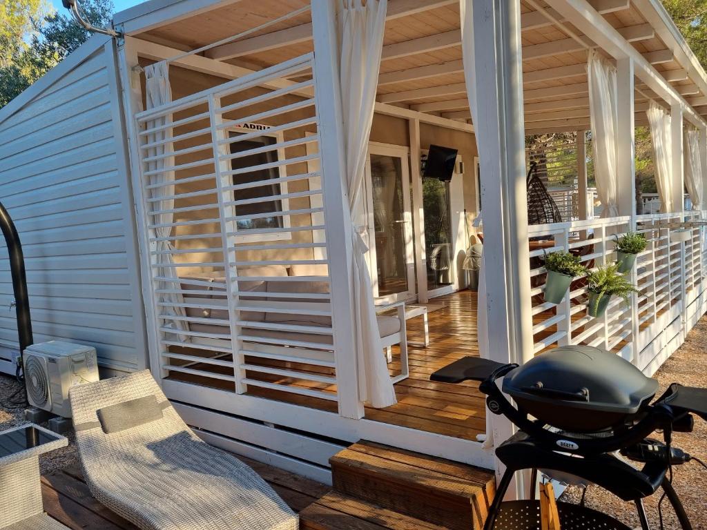 une terrasse couverte d'une maison avec un casque sur un vélo dans l'établissement Premium Mobile Home ZEN SPOT 280, à Jezera