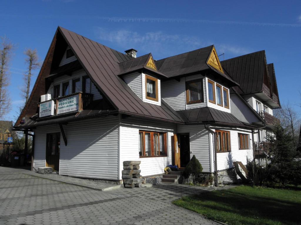 a large house with a gambrel roof at Domek Pod Reglami in Zakopane