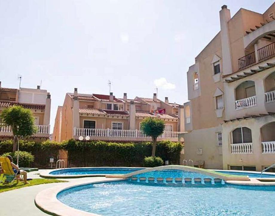 a large swimming pool in front of a building at Villas Del Mar 2-bedroom Apartment with Swimming pool in Torrevieja