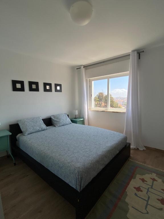 een slaapkamer met een bed en een groot raam bij Suites Setúbal - River View in Setúbal