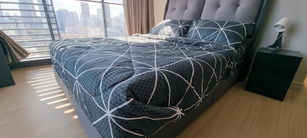 1 dormitorio con cama con edredón y ventana en Continew Residence by Mikey - Premium Unit, en Kuala Lumpur
