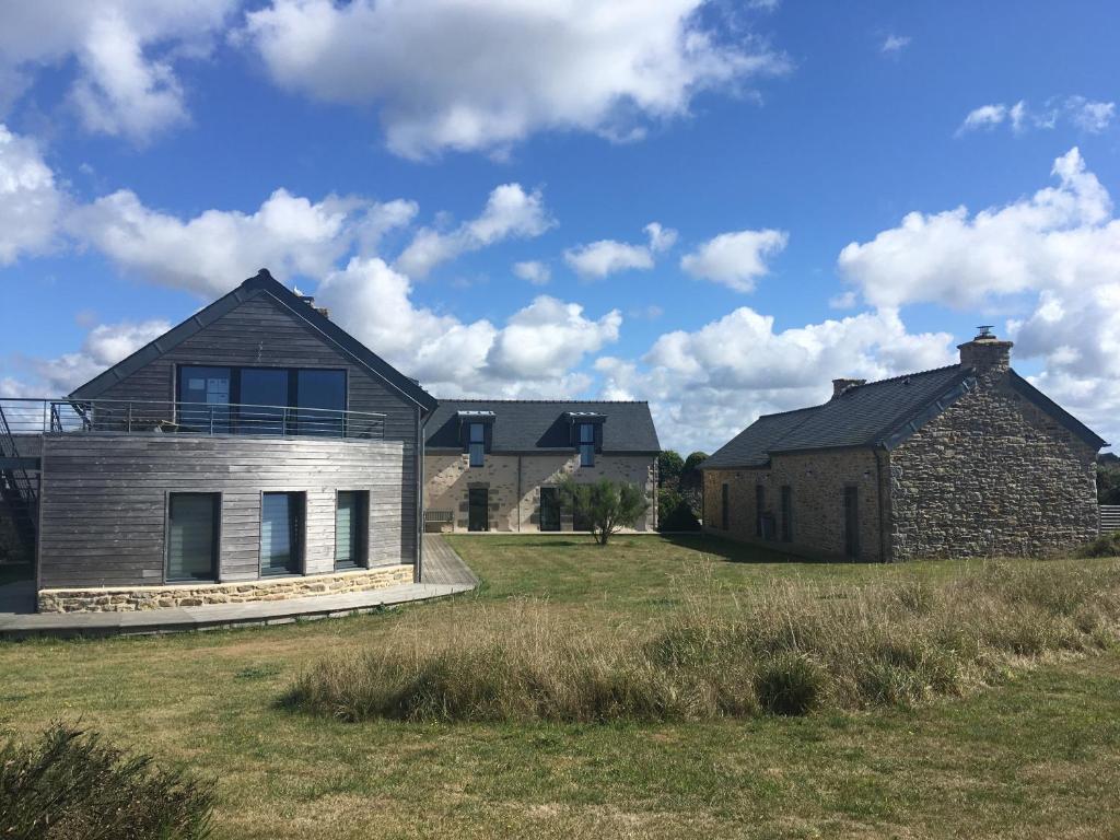 ein Haus und eine Scheune auf einem Grasfeld in der Unterkunft Le Clos Pen Kear in Plouarzel