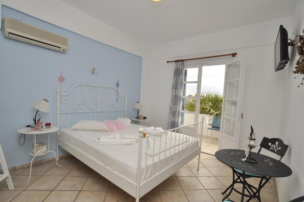 a bedroom with a bed and a balcony at Manos Apartments in Megas Yialos-Nites