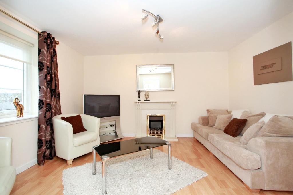 een woonkamer met een bank en een tv bij Fonthill Apartments in Aberdeen