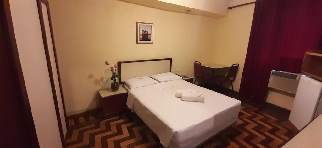 a small bedroom with a bed and a mirror at Itajubá Hotel in Rio de Janeiro