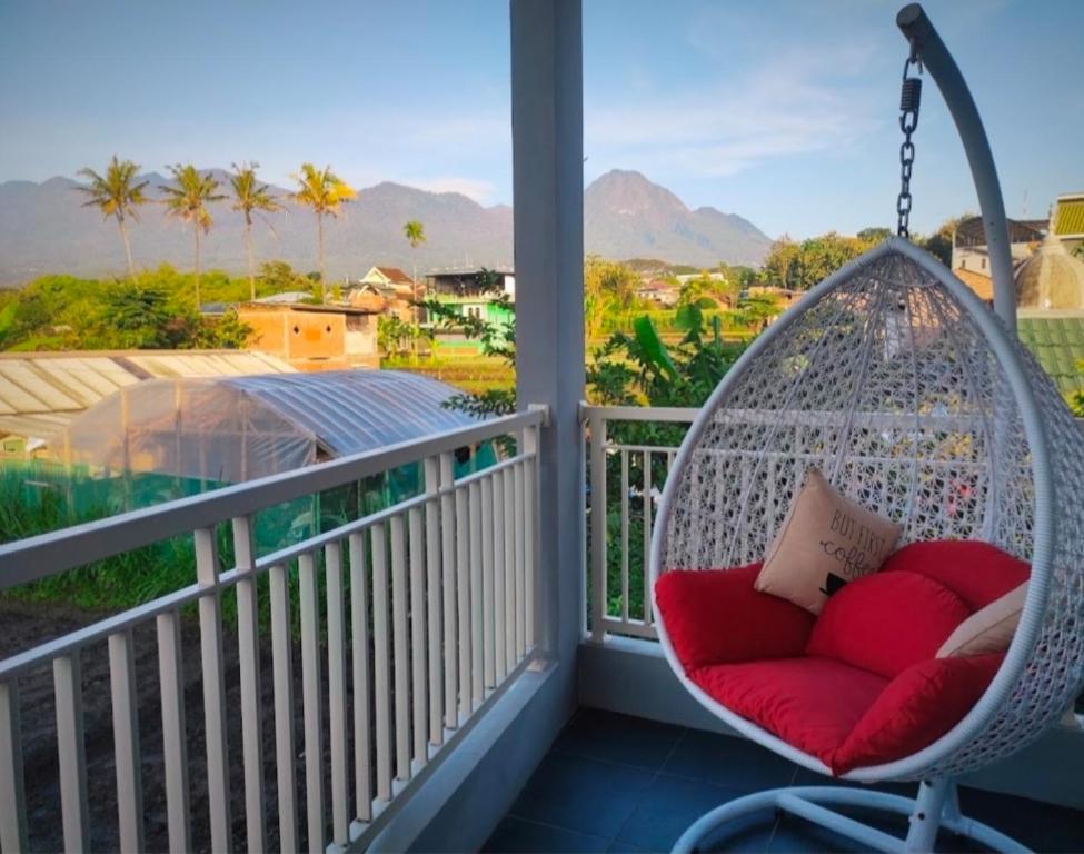 a swing on a porch with a view of the mountains at Family Villa C37 Batu in Batu