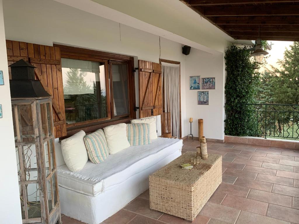 een woonkamer met een witte bank en een raam bij ZeusPlace Olympus Olive Country House 2 in Leptokarya