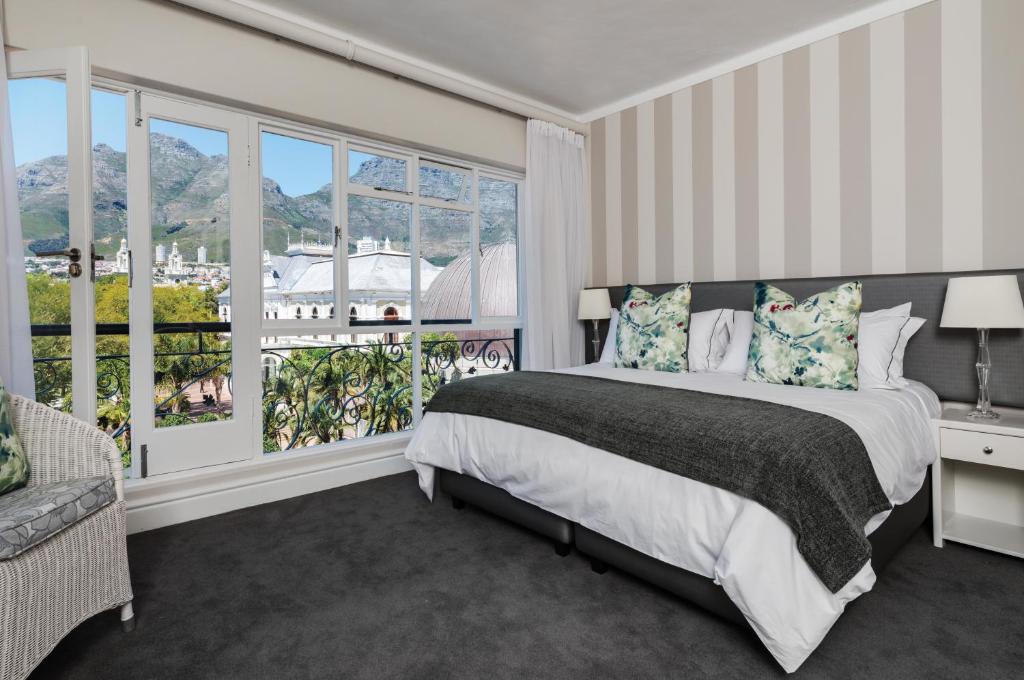 a bedroom with a bed and a large window at Cape Town Hollow Boutique Hotel in Cape Town