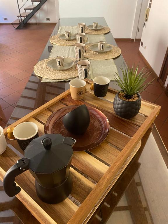 una mesa con platos y tazones y una olla en ella en LHE Beating Heart Casa Tiziana, en Cesena