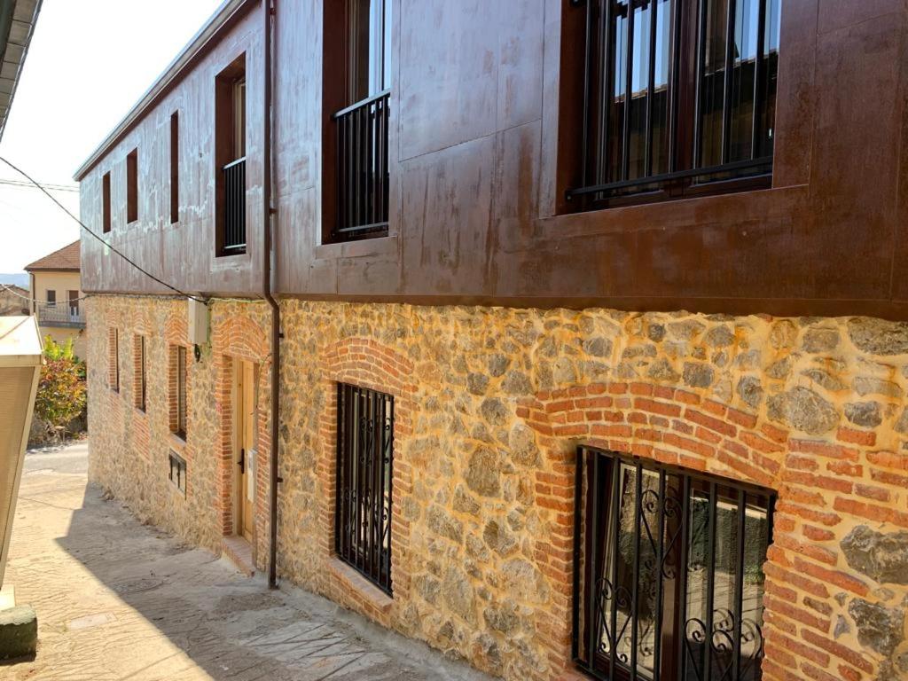 a brick building with black barred windows on it at Apartamentos Tierra y Arte in Santoña