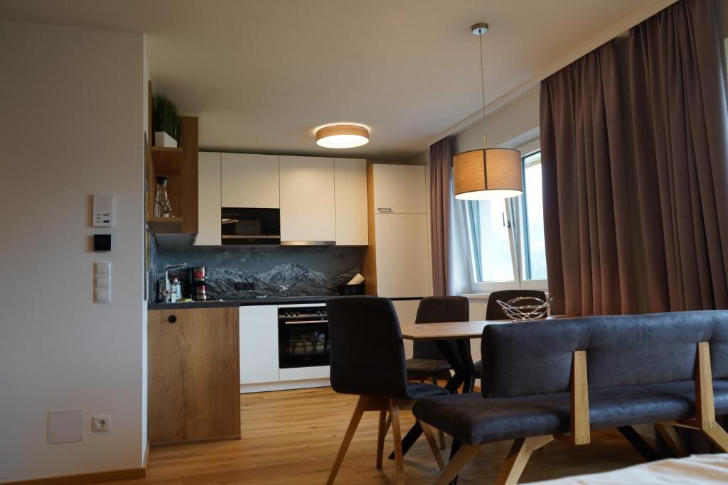 uma cozinha e sala de jantar com mesa e cadeiras em Sun Hill em Schladming