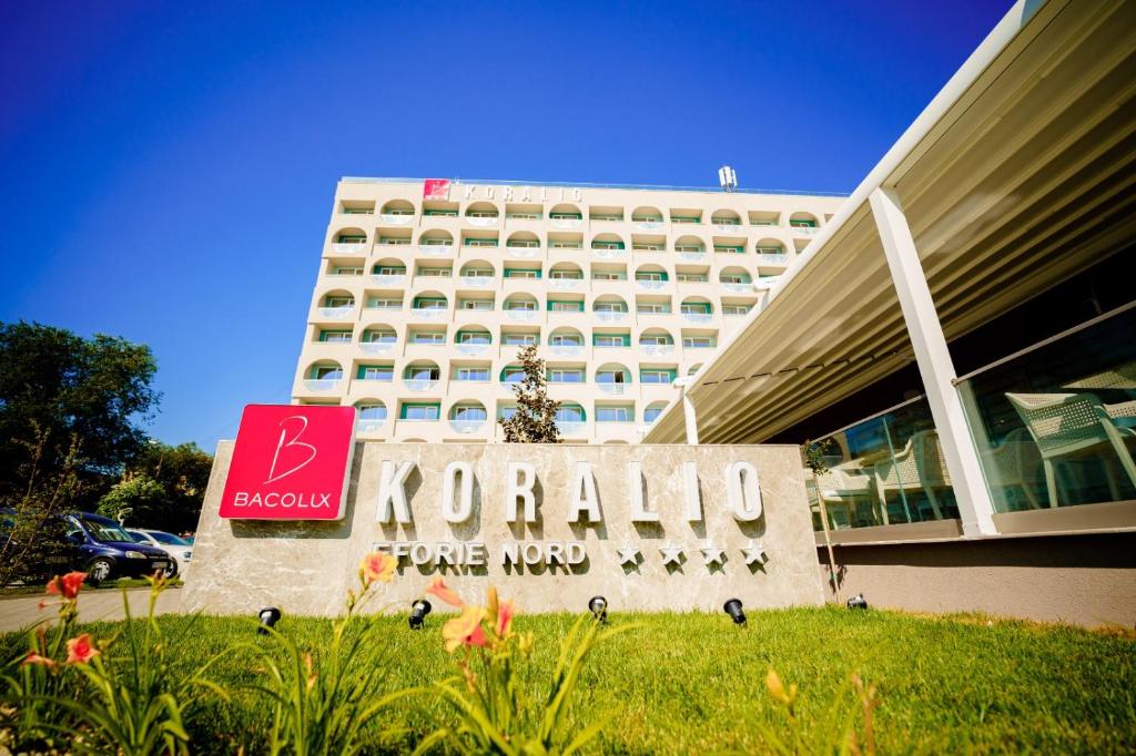 uma placa de hotel em frente a um grande edifício em Bacolux Koralio, Eforie Nord em Eforie Nord