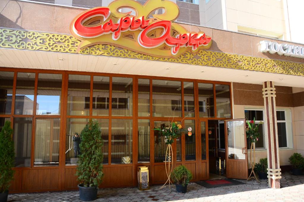 a restaurant with a sign on the front of it at Sary Arka Hotel in Shymkent