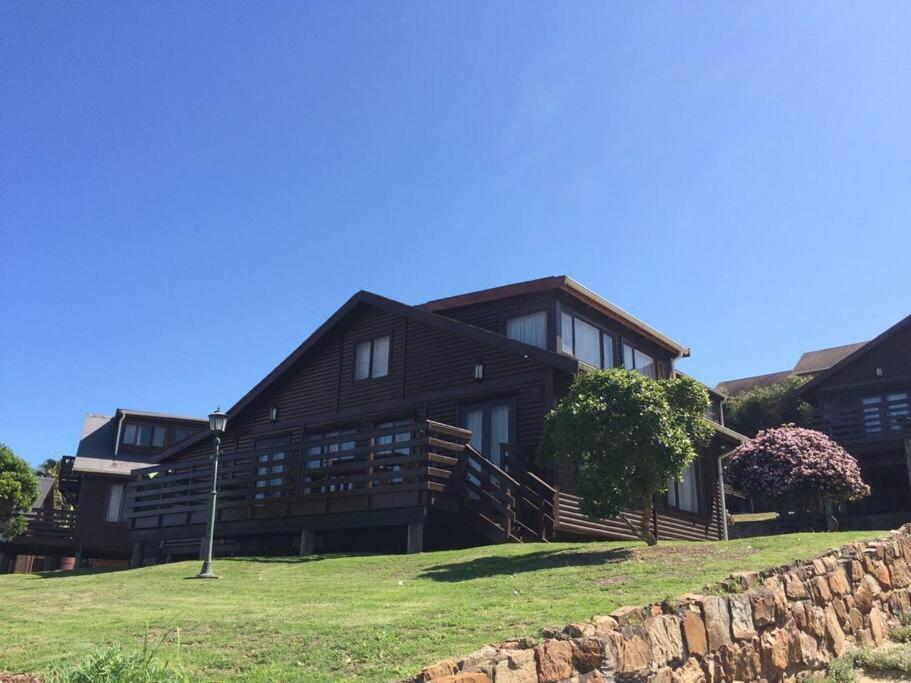 a large wooden house with a stone wall at PA Sands Beach House Kowie River 9 Sleeper Pool in Port Alfred