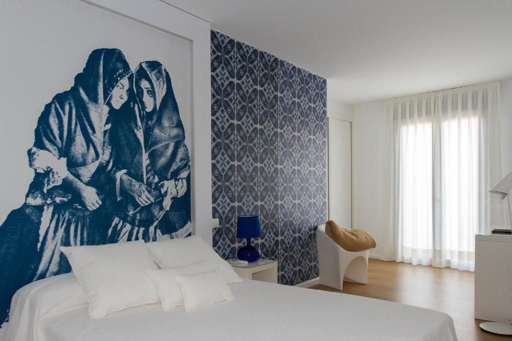 - une chambre avec un lit orné d'une grande peinture murale dans l'établissement Enlakruz, à Lagartera