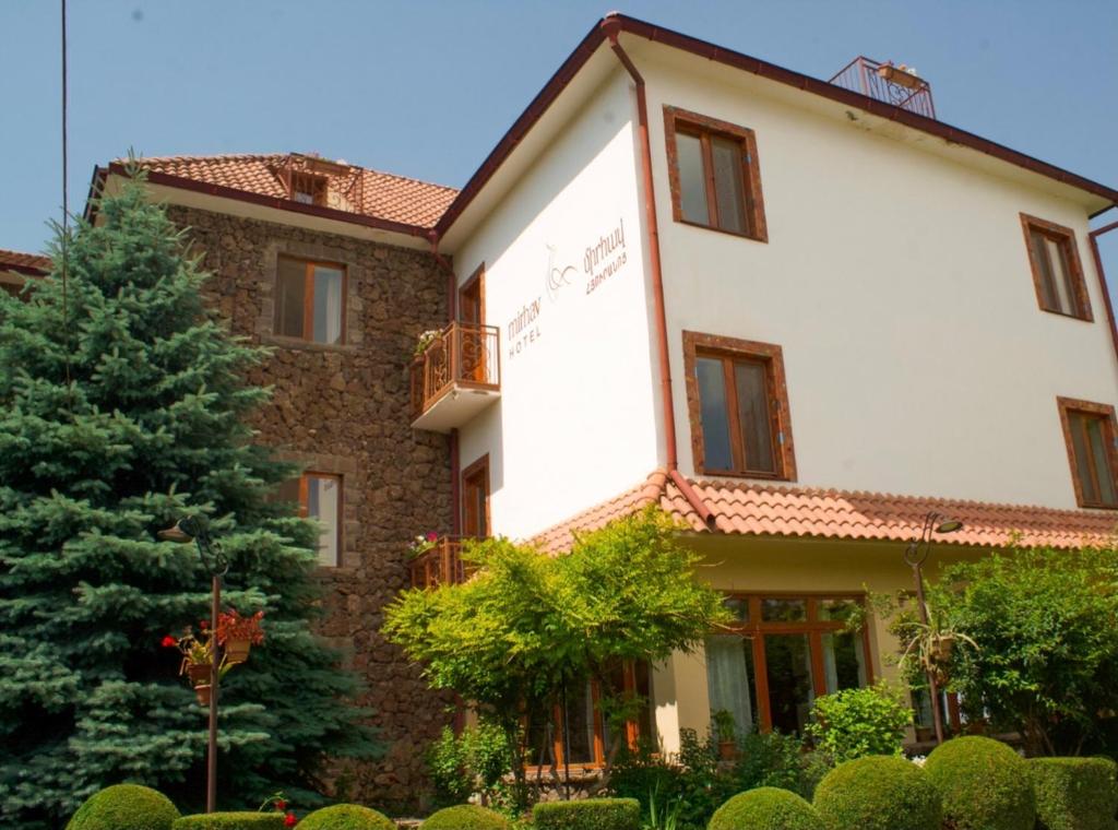 un bâtiment avec un arbre en face dans l'établissement Hotel Mirhav, à Goris
