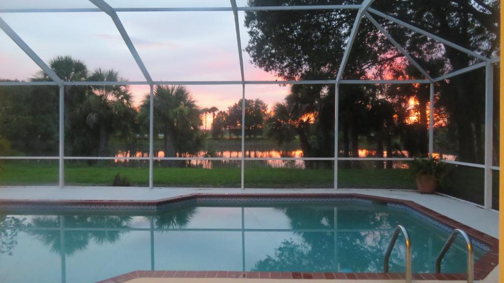 une piscine avec vue sur le coucher du soleil en arrière-plan dans l'établissement Luxury 3-Bedroom Home near Beaches with Pool, à Vero Beach
