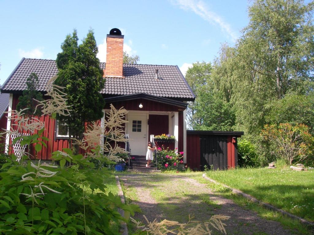 a small red house with a brick chimney on top at Wilderness Cottage in Kloten