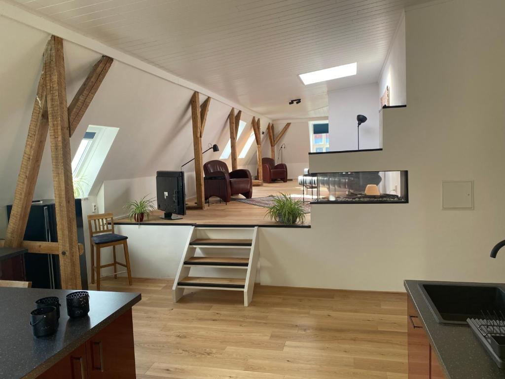 eine Küche und ein Wohnzimmer im Dachgeschoss in der Unterkunft Loft in der alten Spinnerei in Spechtholzhock