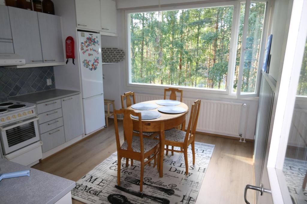 een keuken met een tafel en stoelen en een raam bij 1-Bedroom Apartment with Sauna in Heinola