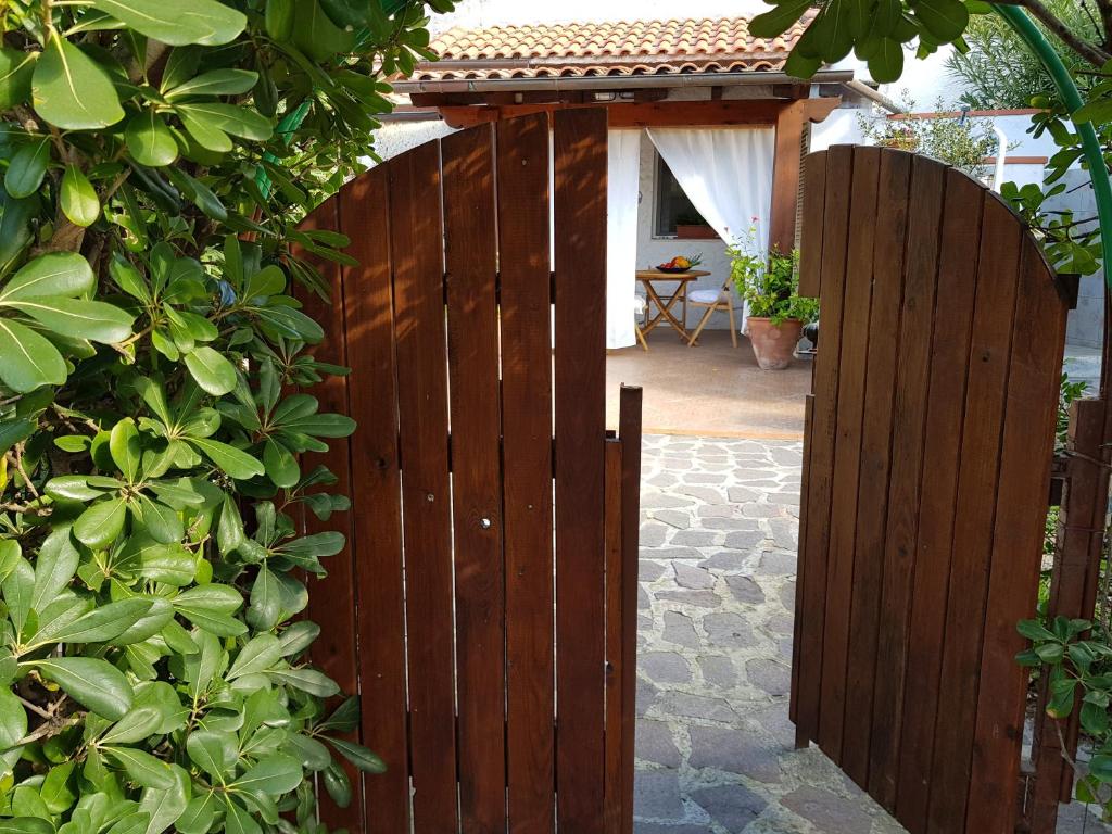 um portão de madeira que dá acesso a um quintal com um pátio em Casa Ibiscus em Palazzo