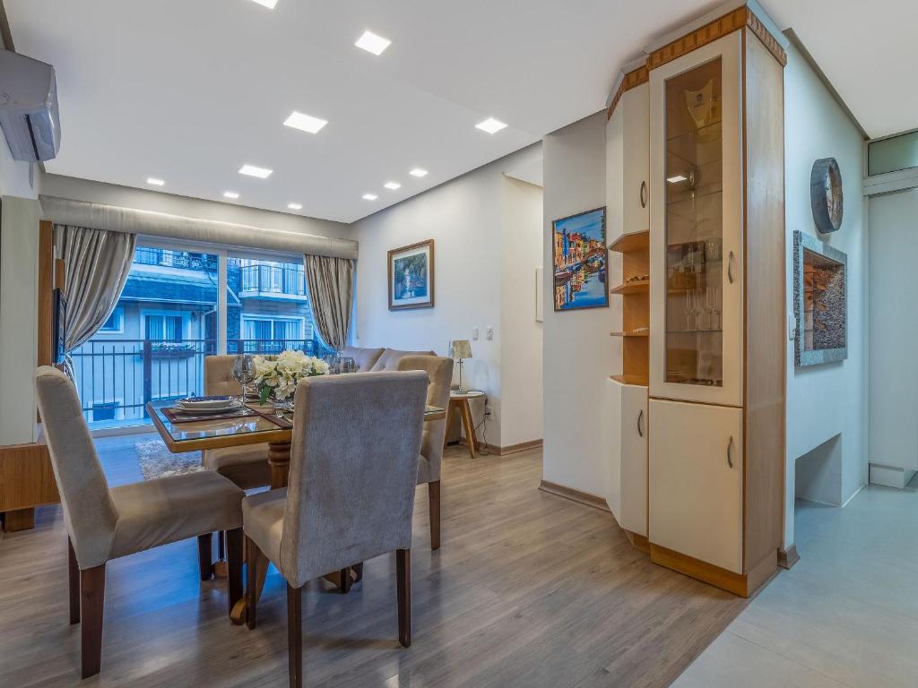 une salle à manger avec une table et des chaises dans l'établissement Casa de Pedra - 301D - Apto com piscina em Gramado, à Gramado