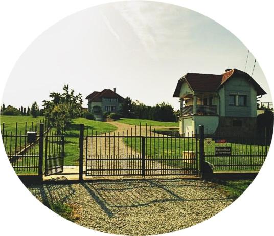 una cerca frente a una casa con una casa en Kleines Haus, en Hévíz