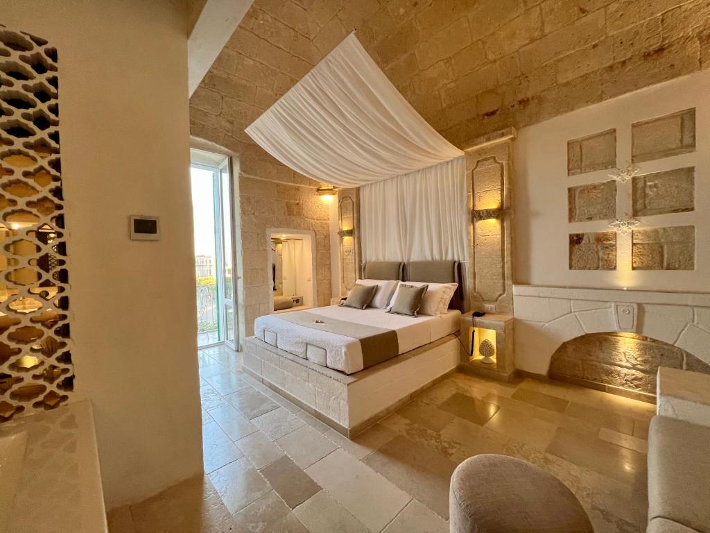 um quarto grande com uma cama e uma lareira em Vittorio Emanuele Charming Suites em Monopoli