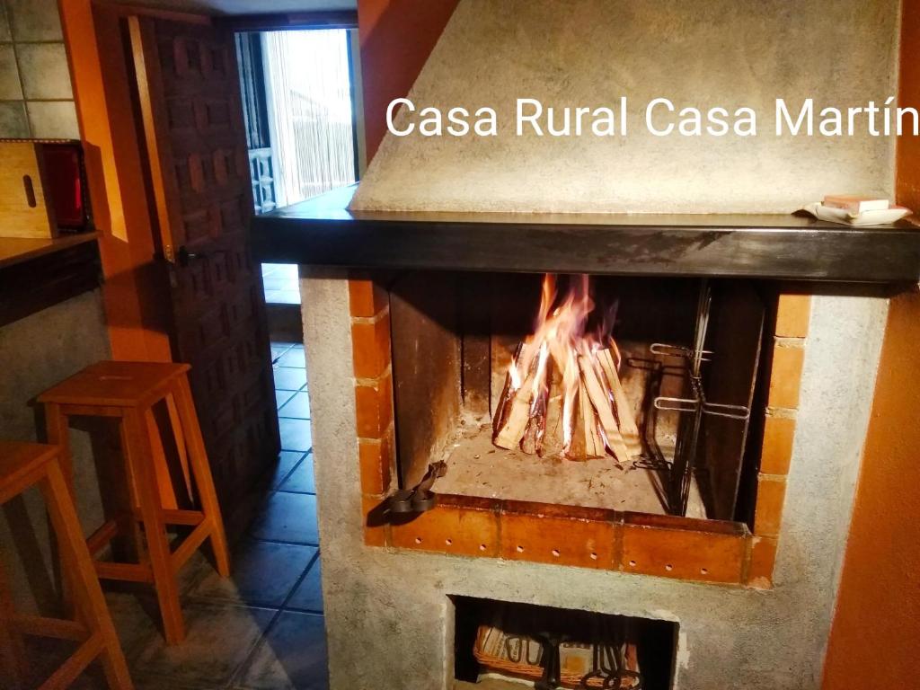 a brick fireplace with a fire in it at Casa Rural Casa Martin in Cueva de Ágreda