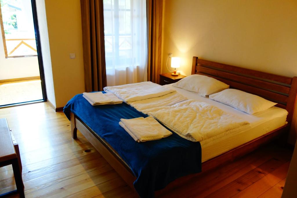 a bedroom with a bed with two towels on it at Guesthouse Mountain View in Mestia