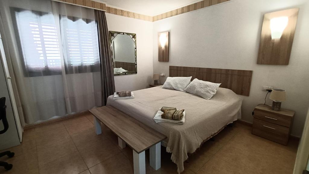 sypialnia z łóżkiem z ławką i lustrem w obiekcie Casa Isabel, the perfect home for your holidays in Corralejo w Corralejo