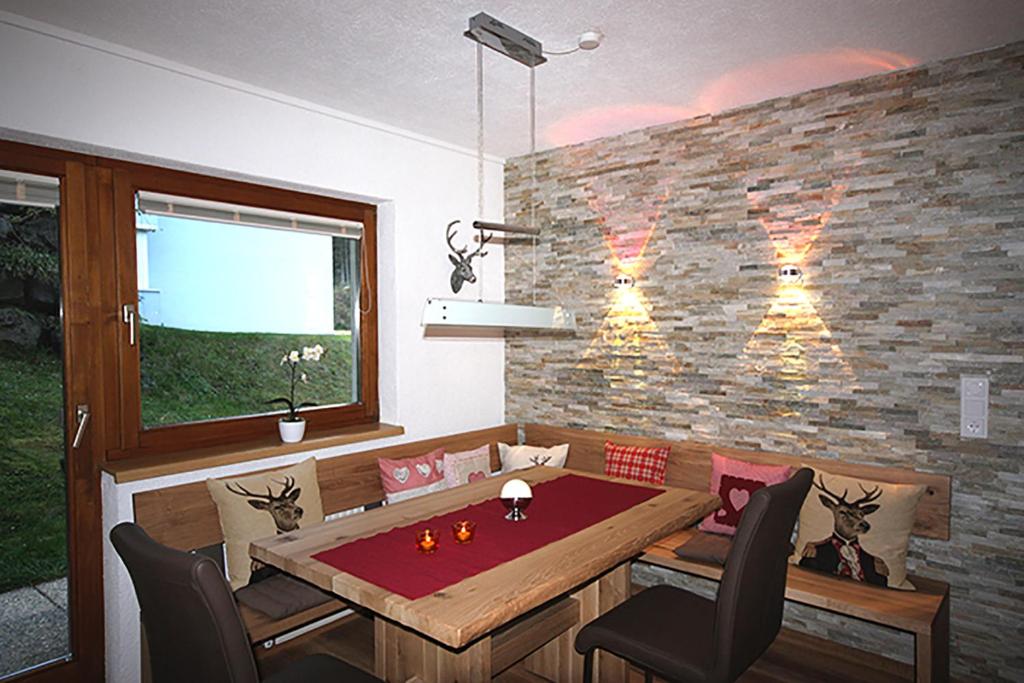 a dining room with a table and a brick wall at Hirschstube in Ischgl