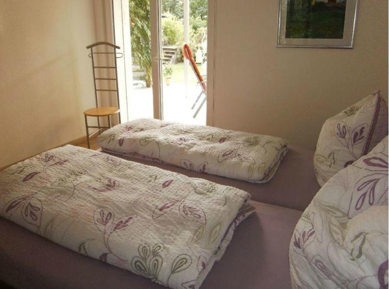 2 Betten in einem Zimmer mit Fenster in der Unterkunft Ferienwohnung Paffendorf in Gutach